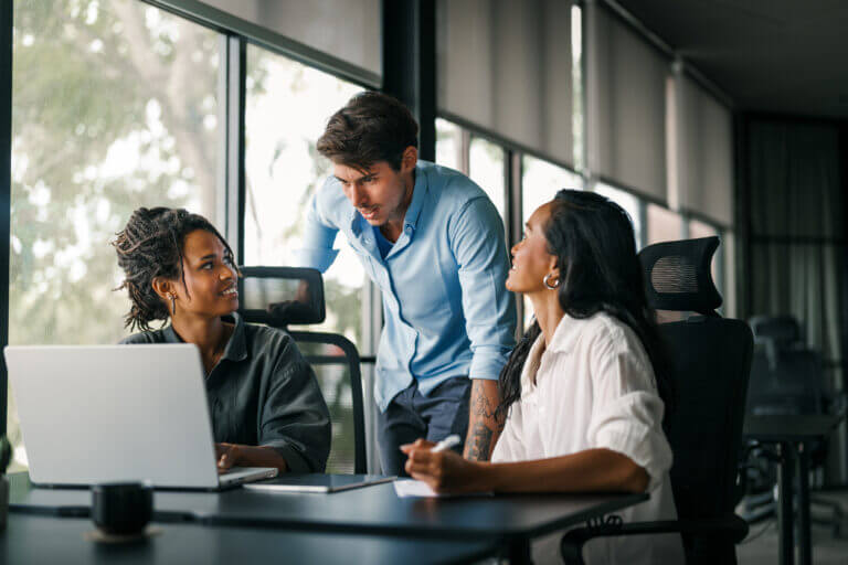Group of young multi-ethnic startup business team collaborating on project in modern office