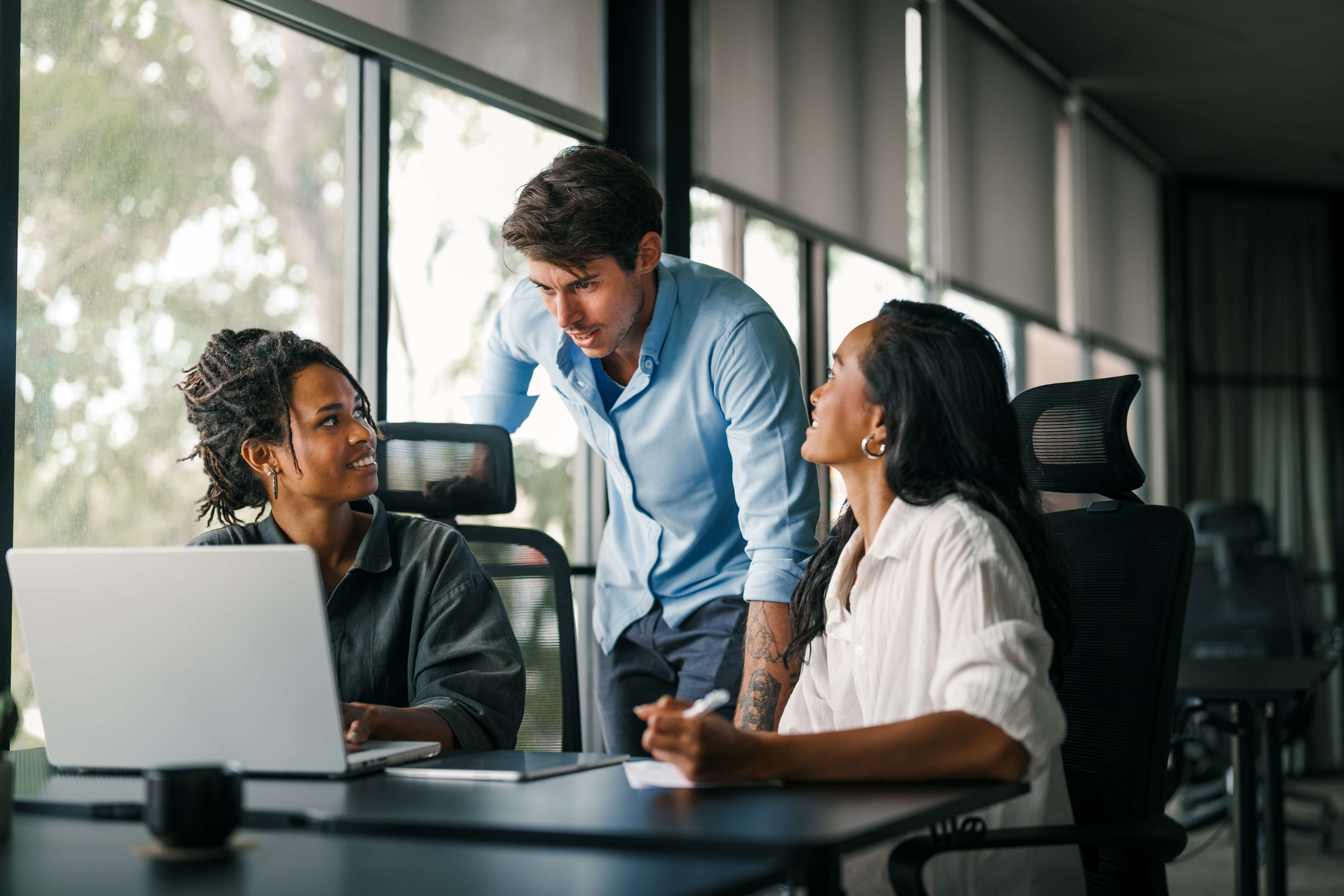 Group of young multi-ethnic startup business team collaborating on project in modern office