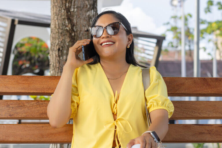 Conectividad al Aire Libre: Mujer Joven y Feliz Hablando por Teléfono en la Ciudad
